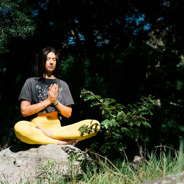 Serene individual meditating in nature, representing energy and calmness.